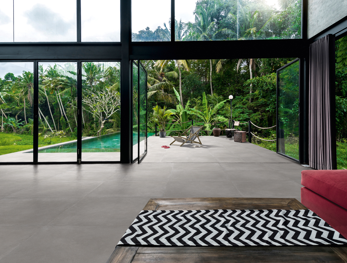 Modern minimalist living room in contemporary design house with glass facade surrounded by lush tropical garden with pool